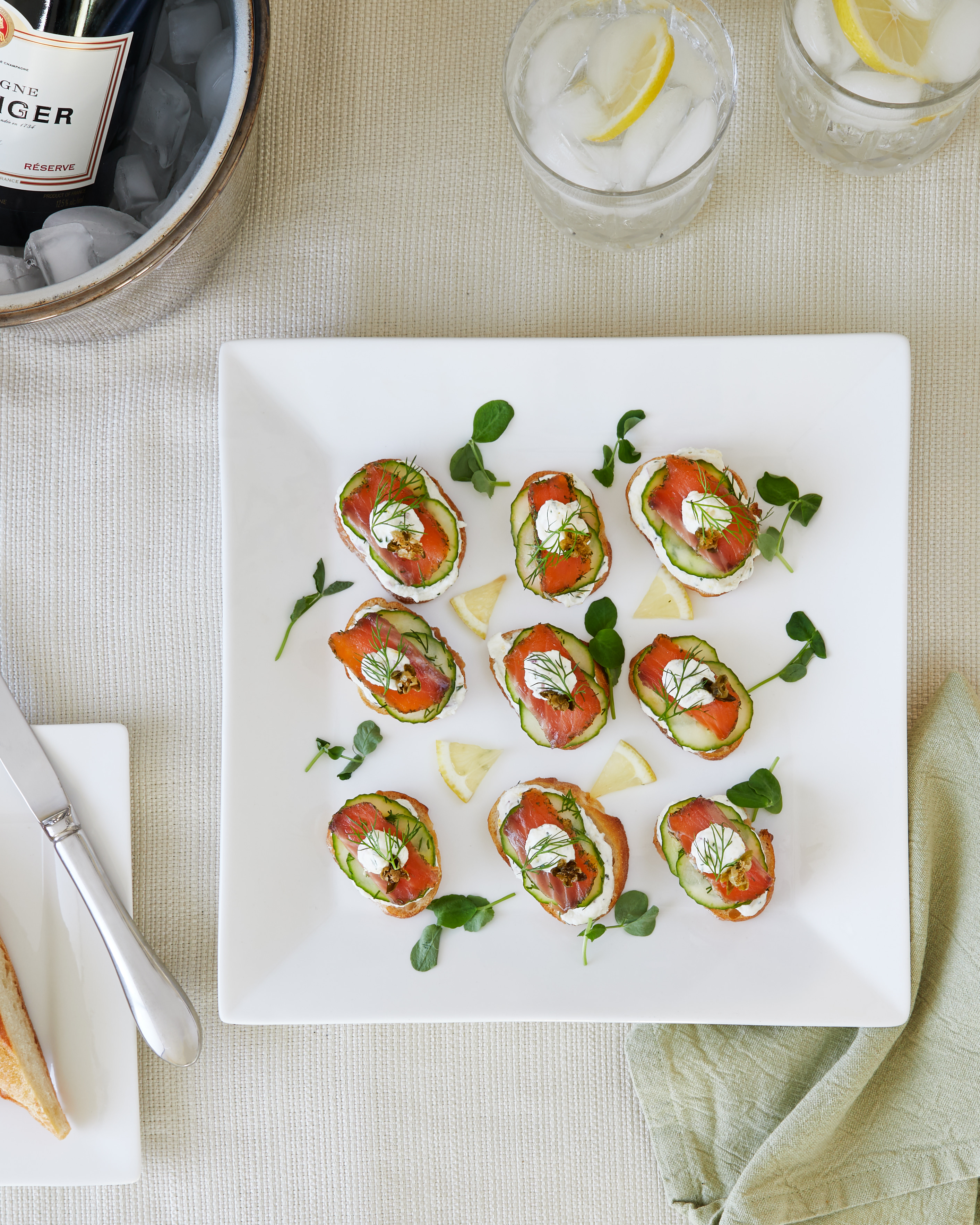 Homemade citrus gin cured salmon on crostini with a dill, caper, lemon crema, fresh cucumber, fried capers, pea shoots and fresh dill. Private Chef Toronto, Private Chef Collingwood